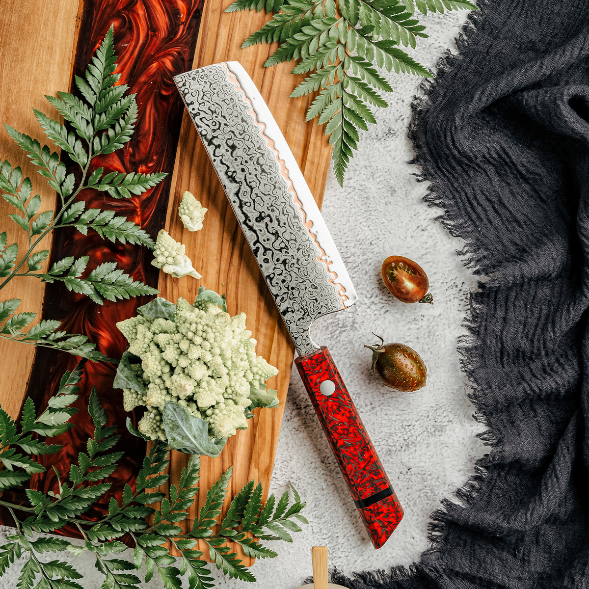 Cuchillo Nakiri 18cm 10Cr+Olas Cobre Damasco54 Resina Roja y Carbono colifor cortado sobre tabla de madera y tomate chileno