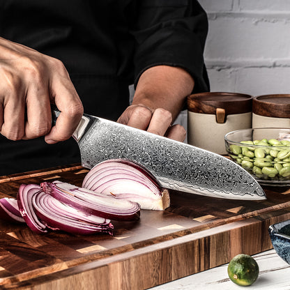 Cuchillo Santoku 18cm 10Cr+Lluvia Damasco66 Mango de Abalón corte de cebolla juliana sobre tabla de picar.