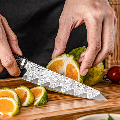 Cuchillo Utilitario 14cm AUS10+Torcido Damasco66 Resina de Carbono y Dorada cortando lima naranjada sobre tabla de picar de madera