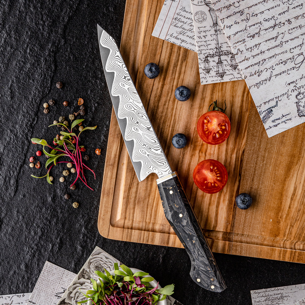 Cuchillo Utilitario 14cm AUS10+Torcido Damasco66 Resina de Carbono y Dorada arandanos y tomate y brotes sobre tabla de madera de picar