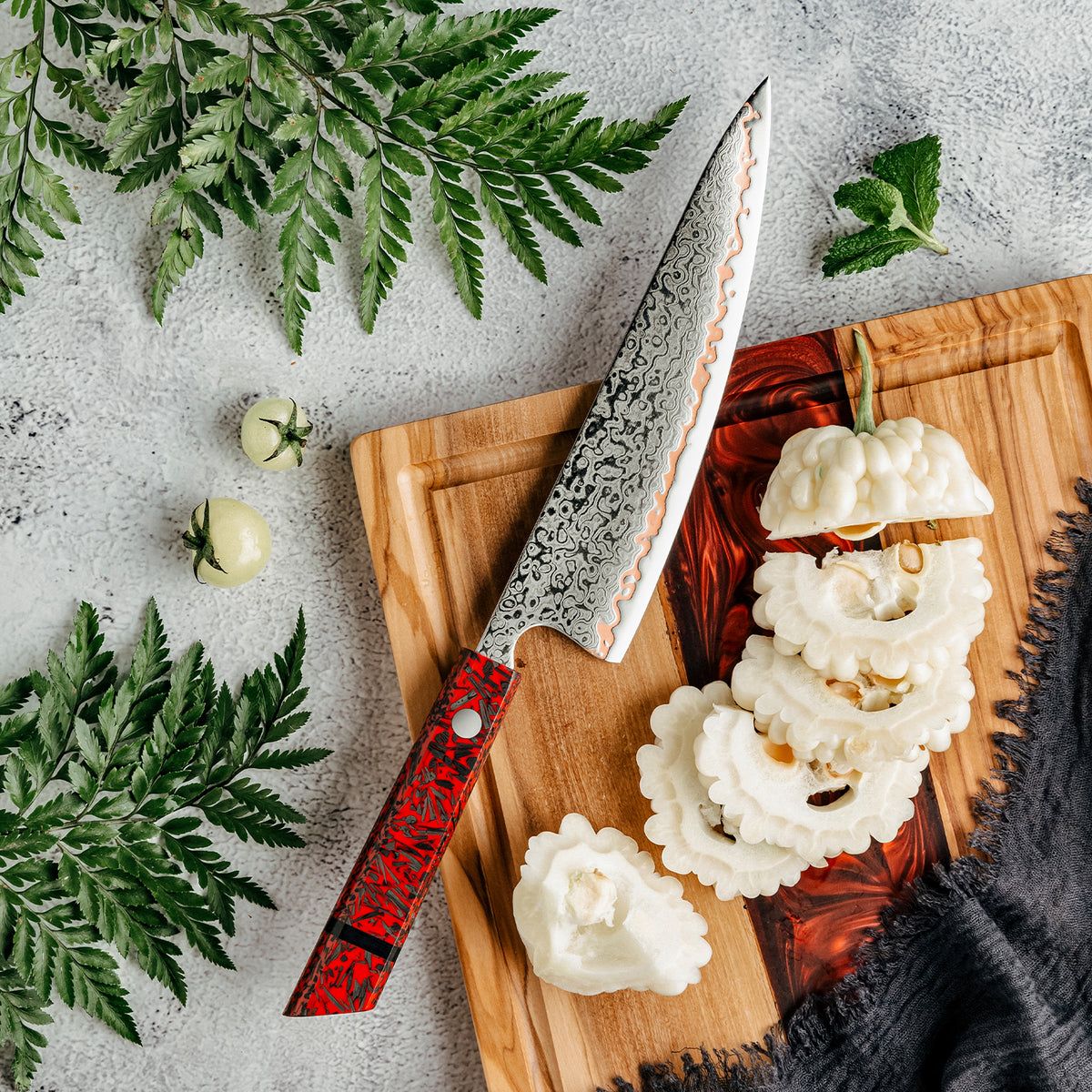 Cuchillo Gyuto 20cm 10Cr+Olas Cobre Damasco54 Resina Roja y Carbono sobre tabala de picar de madera y resina con verduras cortadas