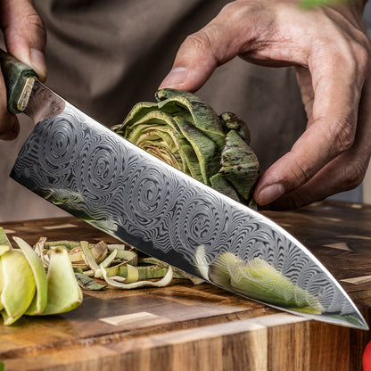 Cuchillo de Chef 22cm 10Cr+Rosa Damasco66 Madera EST Verde y Cobre, sobre una tabla de picado con lechugas previamente cortadas.