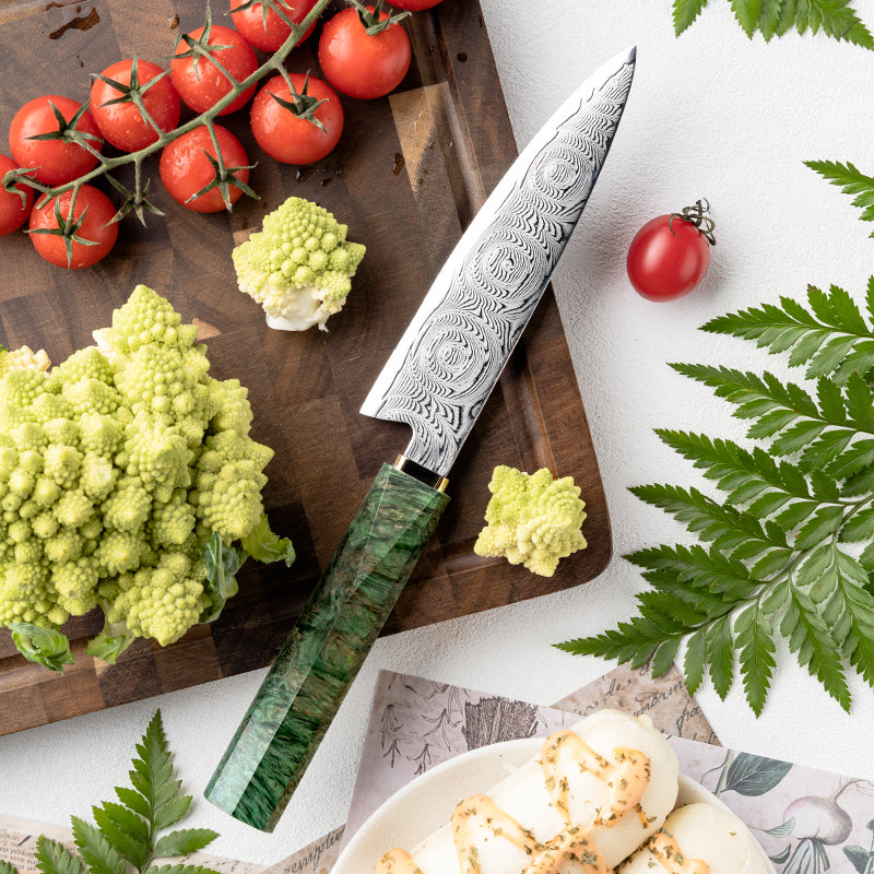 Cuchillo Utilitario 14cm 10Cr+Rosa Damasco66 Madera EST Verde y Cobre puesto sobre tabla de picar a la testa con cortes de brocoli, acompañado con tomate chery