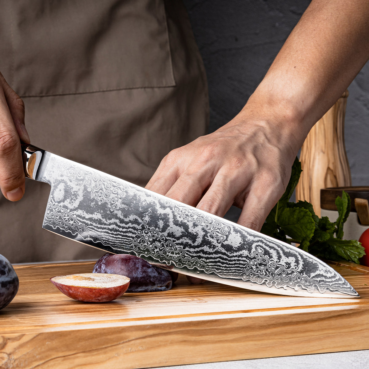Cuchillo de Chef 21cm S35VN+Ola Damasco66 Resina Roja y Carbono sobre una mesa de picar.
