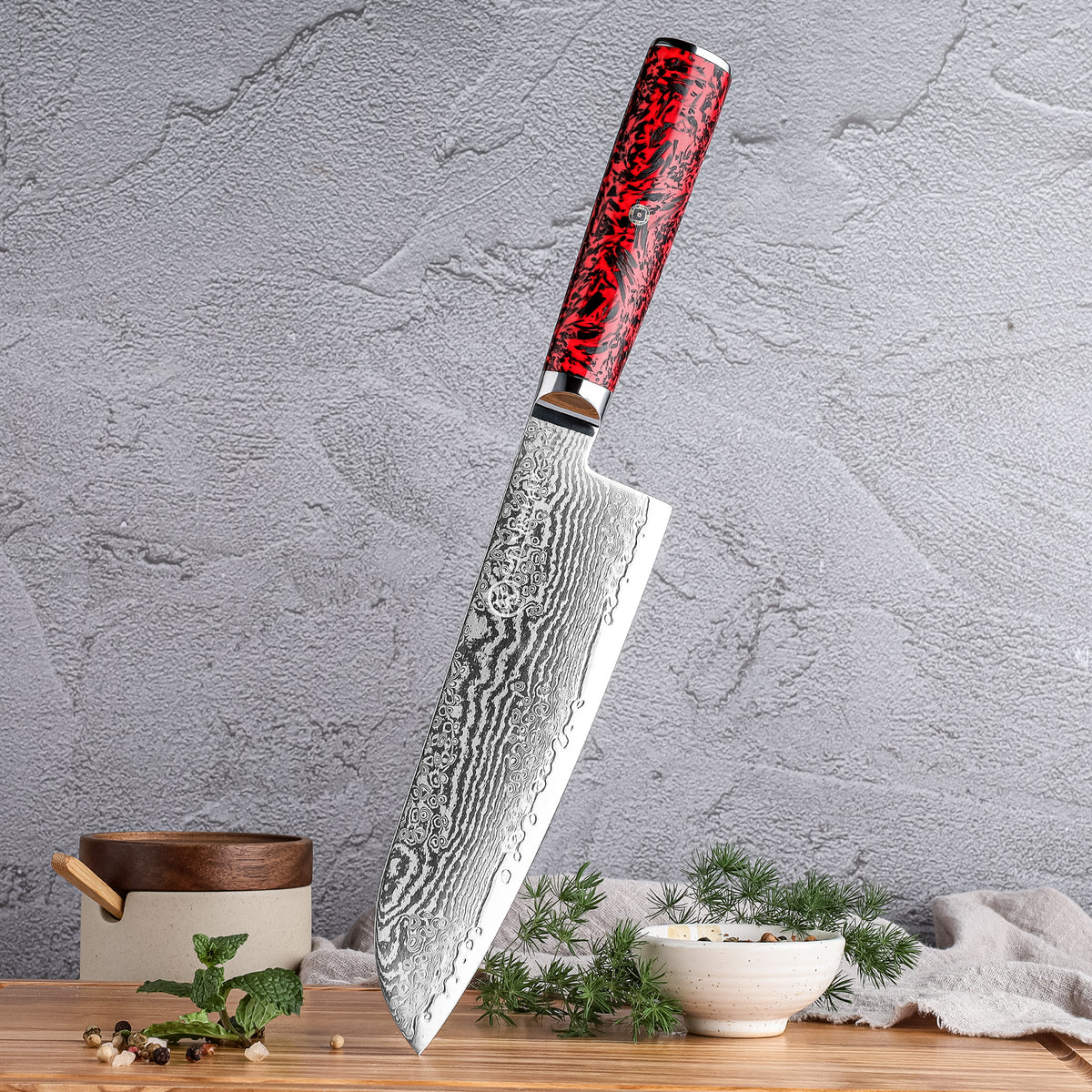 Cuchillo Santoku 18cm S35VN+Ola Damasco66 Resina Roja y Carbono sobre una tabla de picar con fondo de pared acompañado con hirebas aromáticas