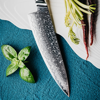 Cuchillo de Chef 20cm 10Cr+Gotas Damasco128 Full Tang Resina Azul, acompañado con hojas de albaca y raices de verduras