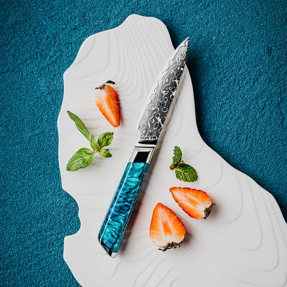Cuchillo Puntilla 10cm 10Cr+Gotas Damasco128 Full Tang Resina Azul cuchillo centrado. acompñado de frutas.