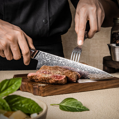 Cuchillo de Chef 20cm 10Cr+Gotas Damasco128 Full Tang Resina Carbono sobre una tabla de picar, cortando carne.