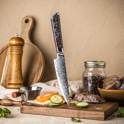 Cuchillo Utilitario 13cm 10Cr+Gotas Damasco128 Full Tang Resina Carbono, cuchillo en el centro, sobre una tabla de picar, verduras, pepino, tomate y pan.