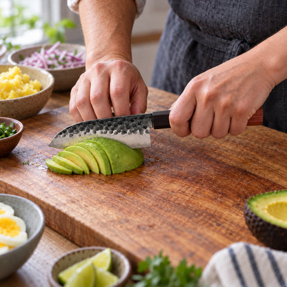 Cuchillo mini santoku de 13 cm cortando palta en láminas finas para causa limeña.