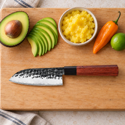 Cuchillo mini santoku de 13 cm sobre tabla con palta, papa amarilla, ají amarillo y limón para causa limeña.
