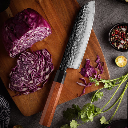 Cuchillo Santoku 19cm AUS-10 Clad Kurouchi Martillado Mango Mkuruti y Ebano, sobre tabla de picar, acompañado kol rojo y cilantro