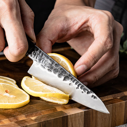 Cuchillo Puntilla 10cm AUS-10 Clad Kurouchi Martillado Mango Mkuruti y Ebano cortando limon.
