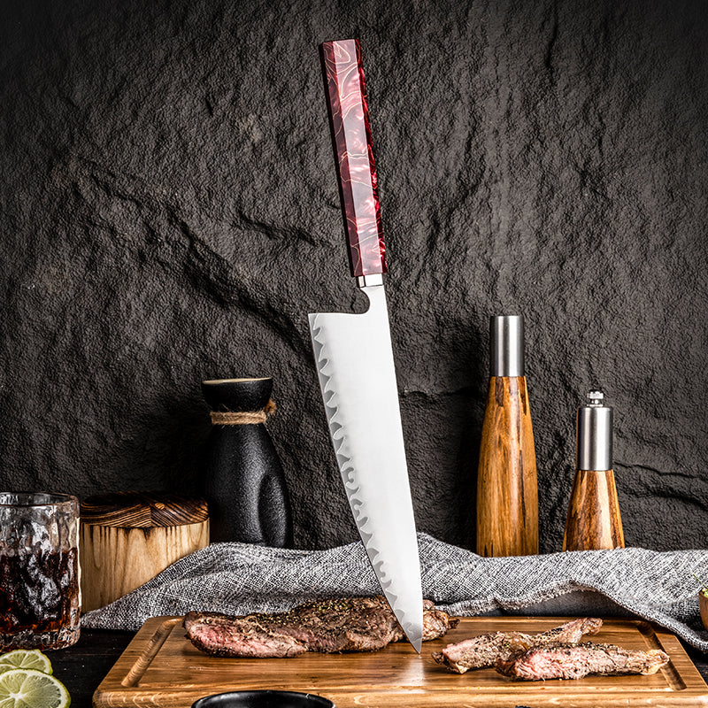 Cuchillo de chef HM-59A de 21 cm en posición vertical con la punta sobre una tabla junto a carne asada.