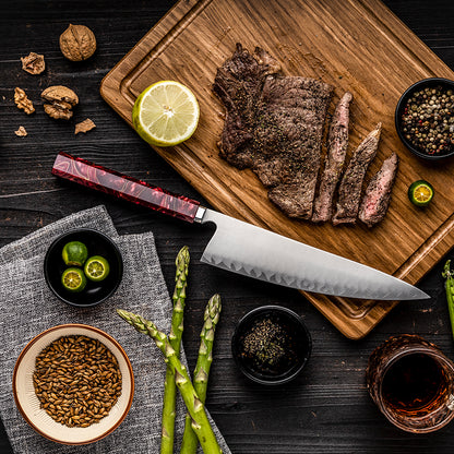 Vista cenital del cuchillo de chef HM-59A de 21 cm junto a carne asada, espárragos y limón.